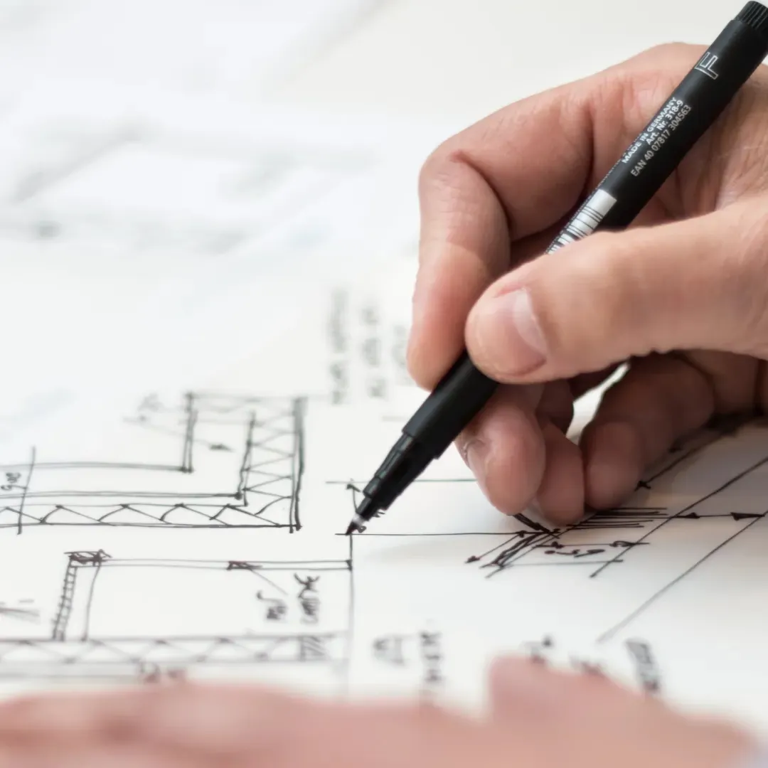 Arquitecto dibujando planos detallados para un nuevo proyecto de construcción.